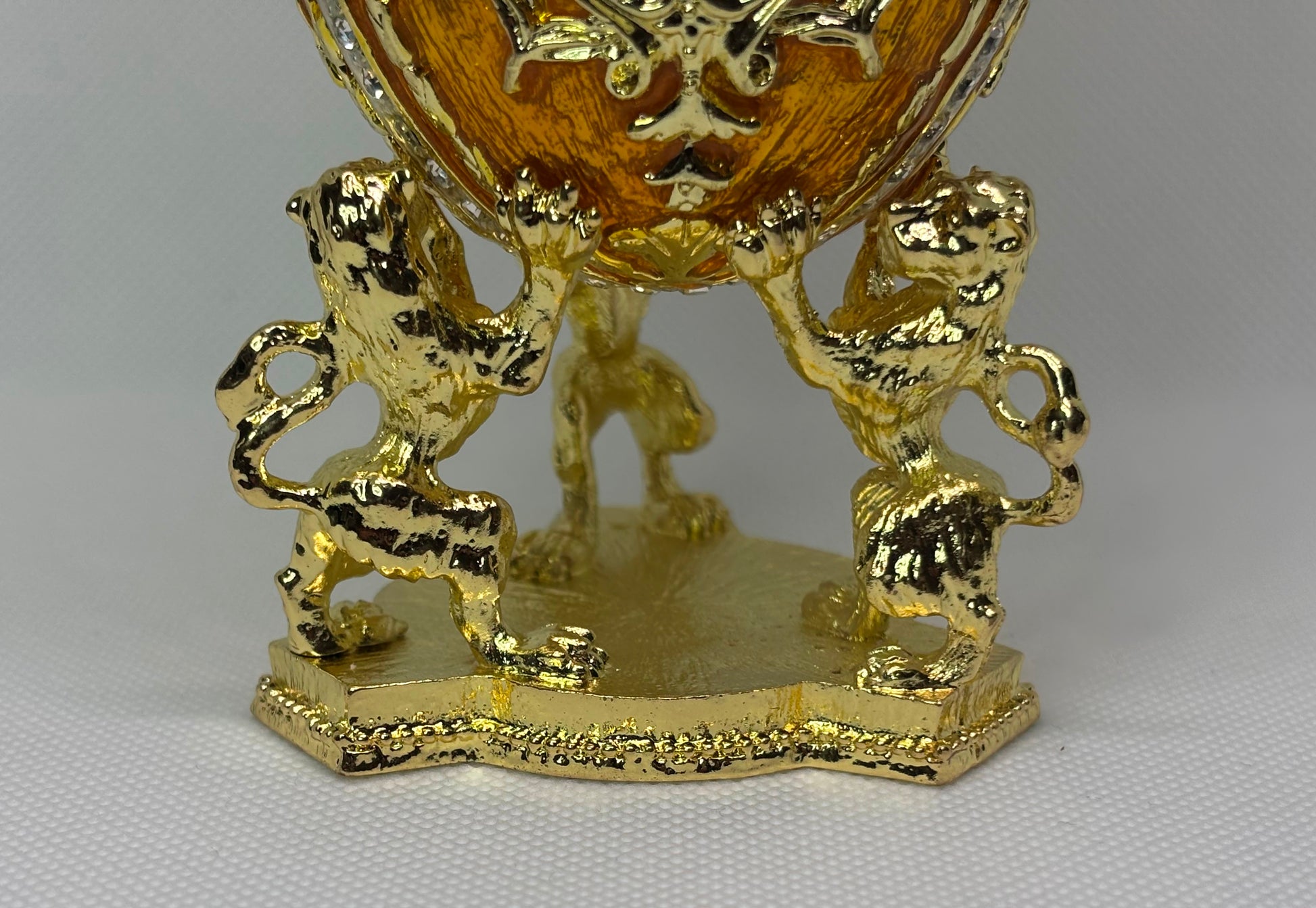 Gold decorative egg with lion figures holding the faberge type egg