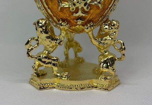 Gold decorative egg with lion figures holding the faberge type egg